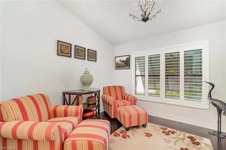 Sitting room featuring vaulted ceiling and dark wood-type flooring