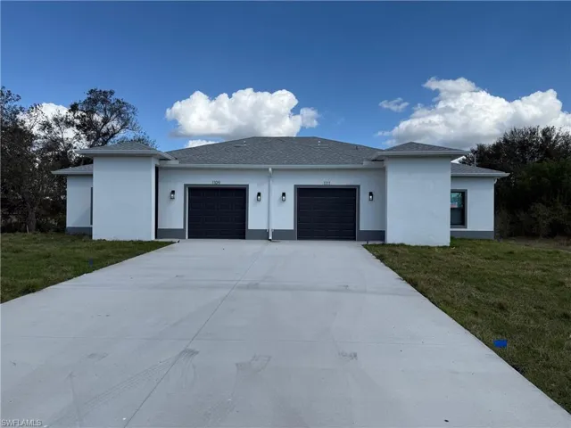 View of front of property featuring a garage and a front yard