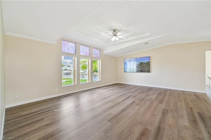 Spare room featuring ceiling fan, hardwood / wood-style flooring, and crown molding
