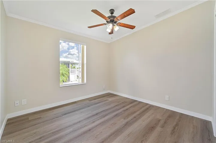 Unfurnished room with crown molding, hardwood / wood-style floors, and ceiling fan