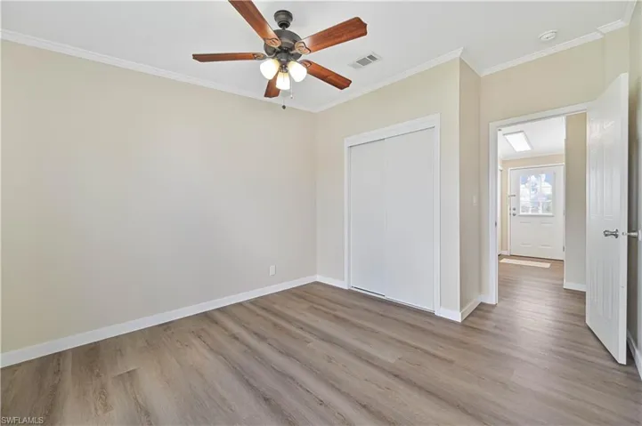 Spare room with crown molding, ceiling fan, and light hardwood / wood-style floors