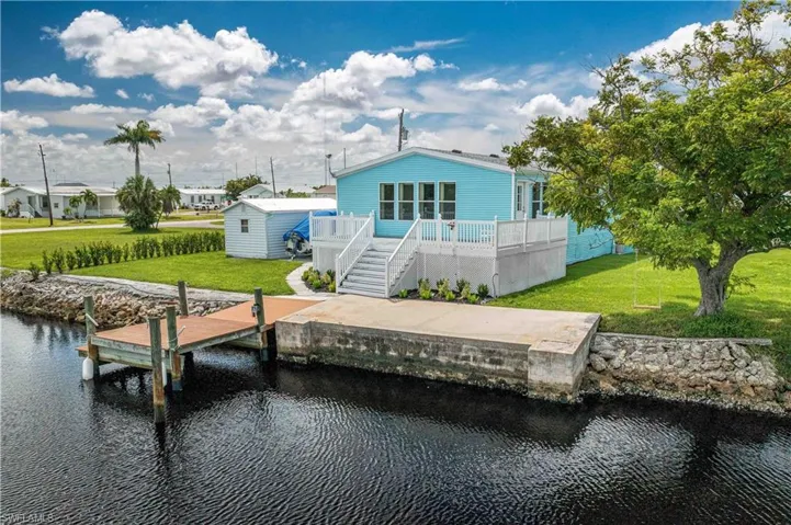 View of dock featuring a lawn and a deck with water view