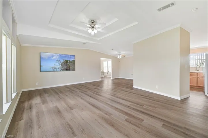 Unfurnished living room featuring crown molding, ceiling fan, and light hardwood / wood-style floors