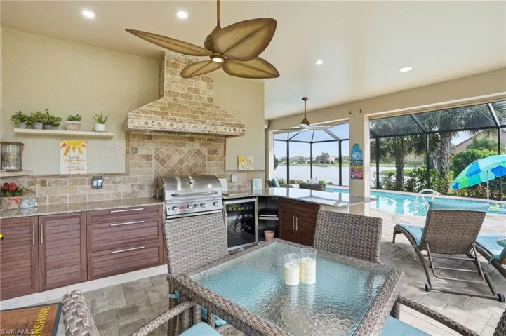 Kitchen with open shelves, light stone counters, brown cabinets, and recessed lighting