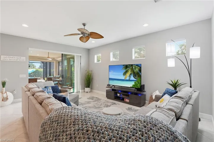Living area featuring healthy amount of natural light, recessed lighting, light tile patterned floors, and a ceiling fan