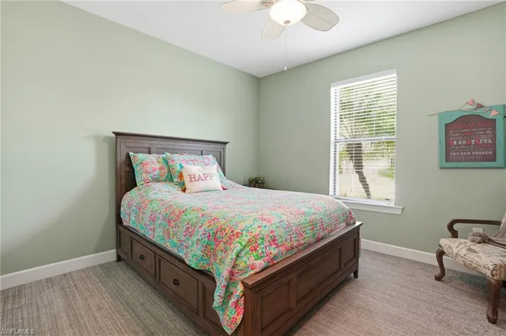 Bedroom featuring a ceiling fan and light colored carpet