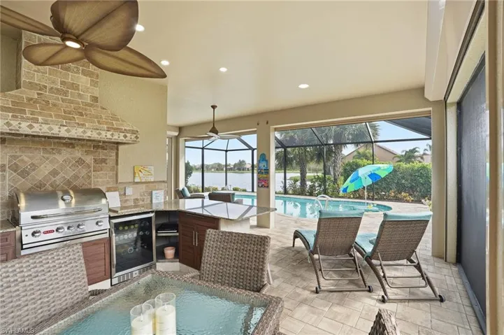 View of patio / terrace featuring a ceiling fan, an outdoor pool, area for grilling, and a sunroom