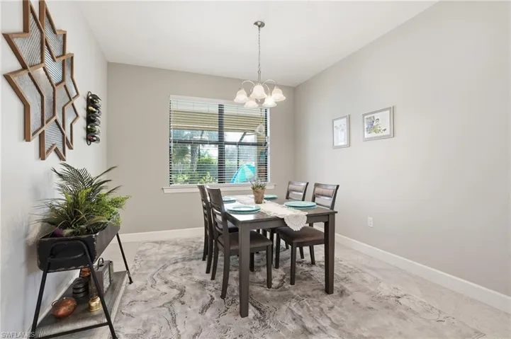 Dining room featuring baseboards and a chandelier