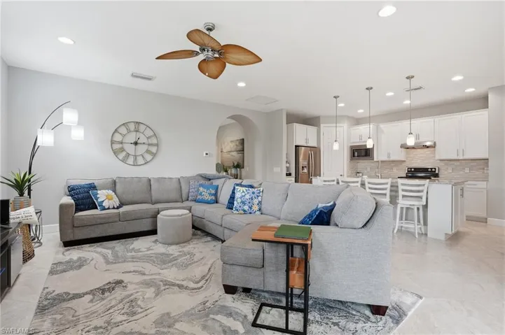 Living room with recessed lighting, a ceiling fan, and arched walkways
