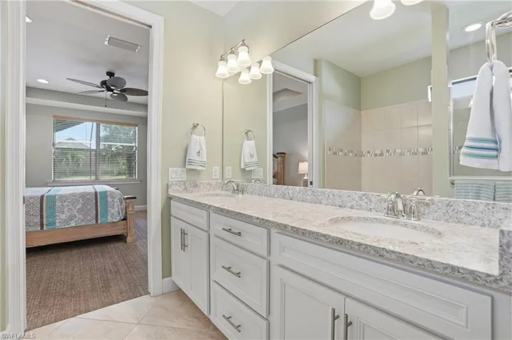 Ensuite bathroom with double vanity, light tile patterned floors, recessed lighting, and a ceiling fan