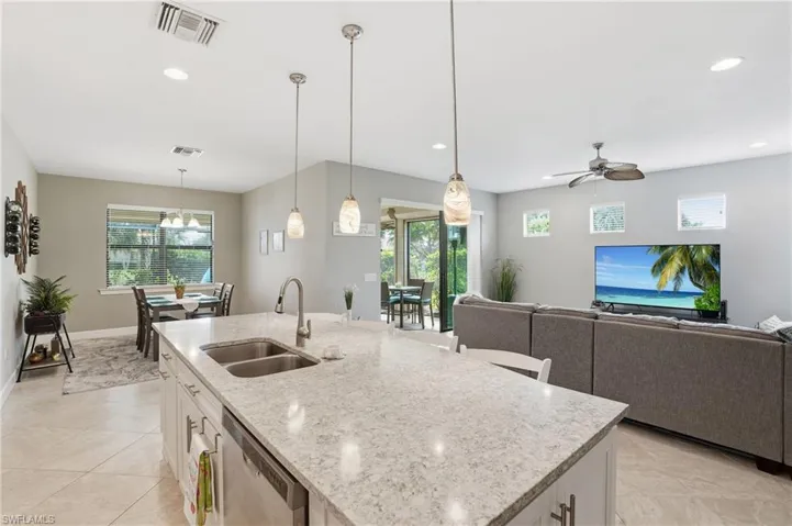 Kitchen with white cabinetry, light stone countertops, pendant lighting, healthy amount of natural light, and recessed lighting