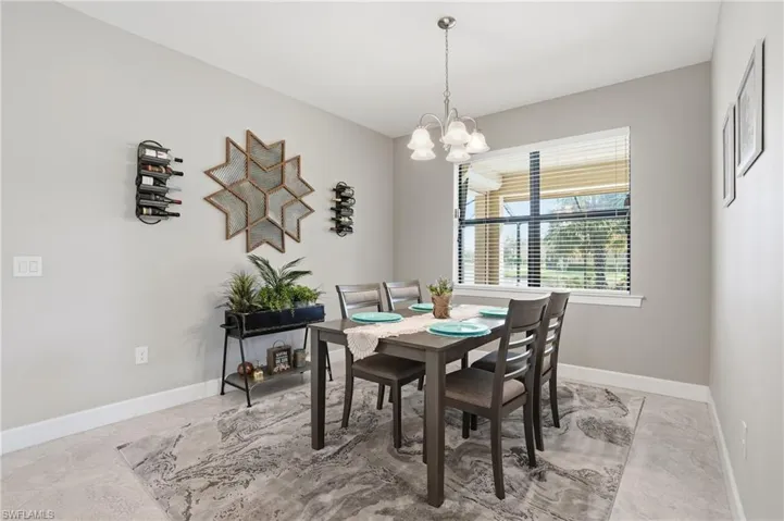 Dining area featuring baseboards and a chandelier