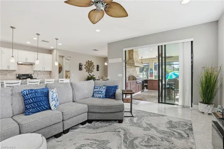 Living room featuring recessed lighting, ceiling fan, and light tile patterned floors