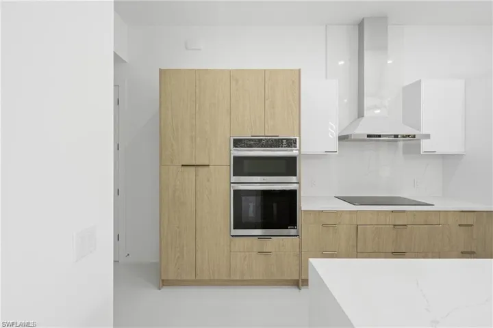 Kitchen featuring dual tone cabinetry, modern cabinets, and stainless steel double oven