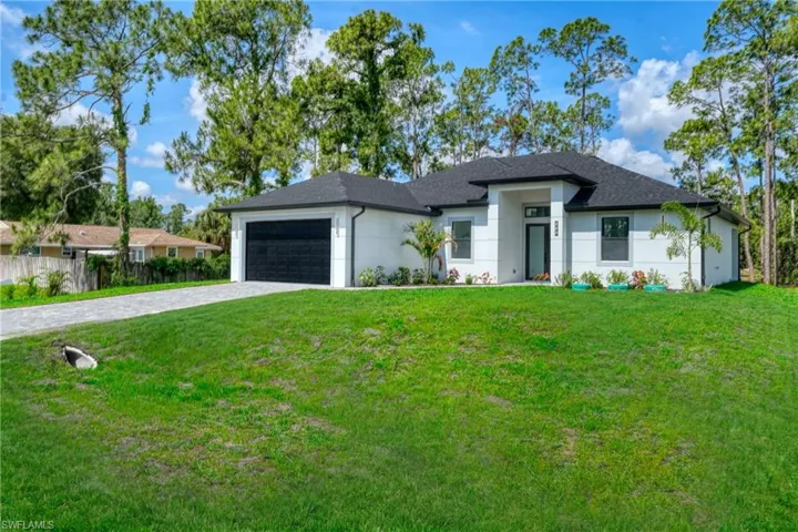 Contemporary single-story residence featuring a white stucco exterior with a black shingle roof