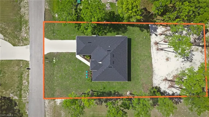Property situated on a spacious lot, featuring a dark shingle roof and a concrete driveway