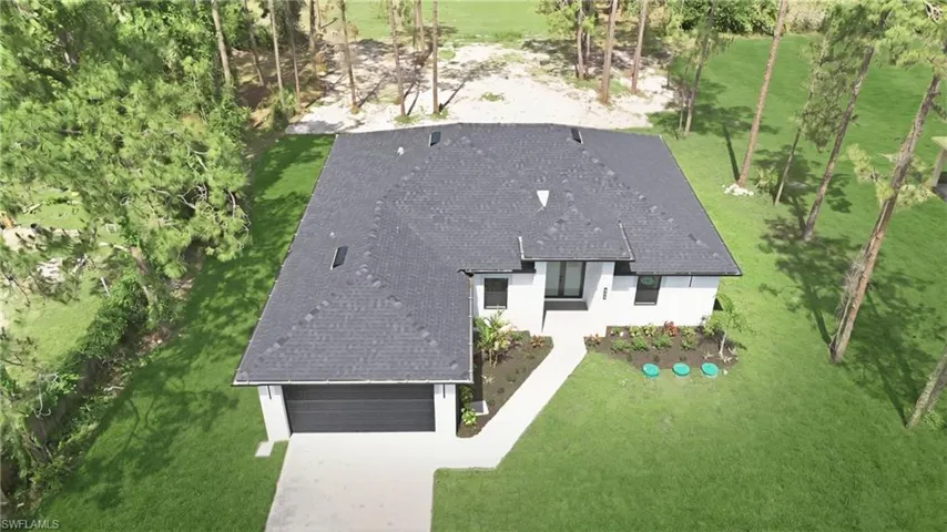 Contemporary single-story residence featuring a dark shingle roof and white exterior walls