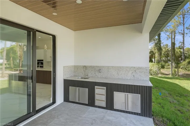 View of patio with area for grilling and ceiling fan