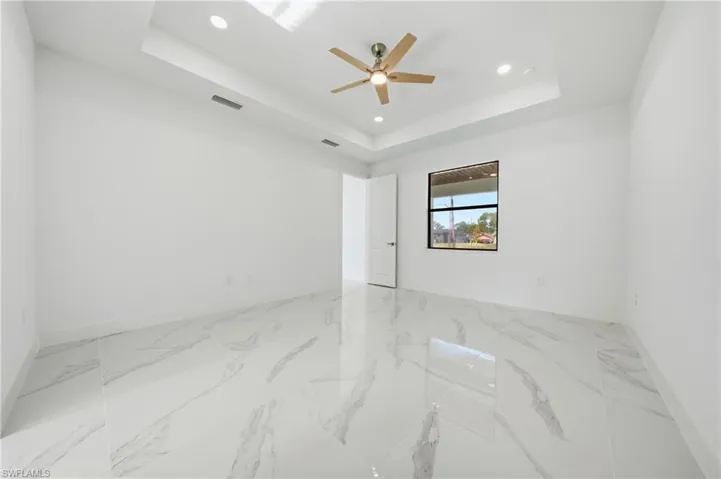 Spacious interior room featuring large format marble-look tile flooring