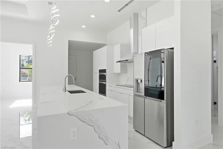 Kitchen featuring dual tone cabinetry, modern cabinets, and stainless steel double oven