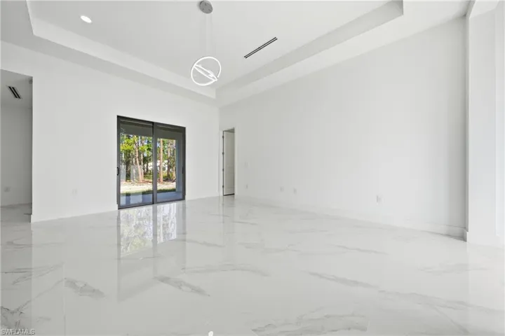Empty room with recessed lighting and a raised ceiling