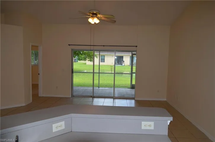 Unfurnished room with light tile patterned floors and ceiling fan