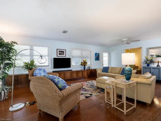 Living room featuring wood flooring, natural light & ceiling fan