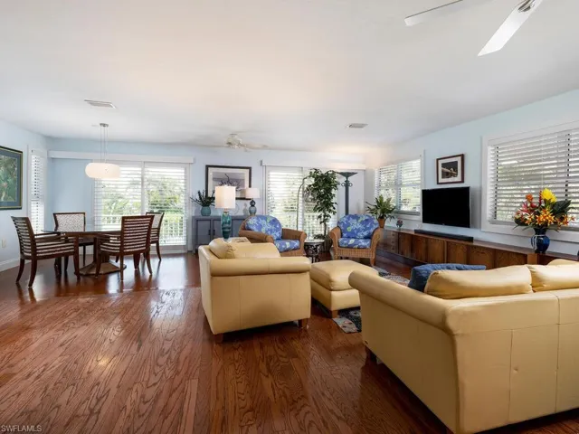 Living area with dark wood flooring, ceiling fan, and plenty of natural light