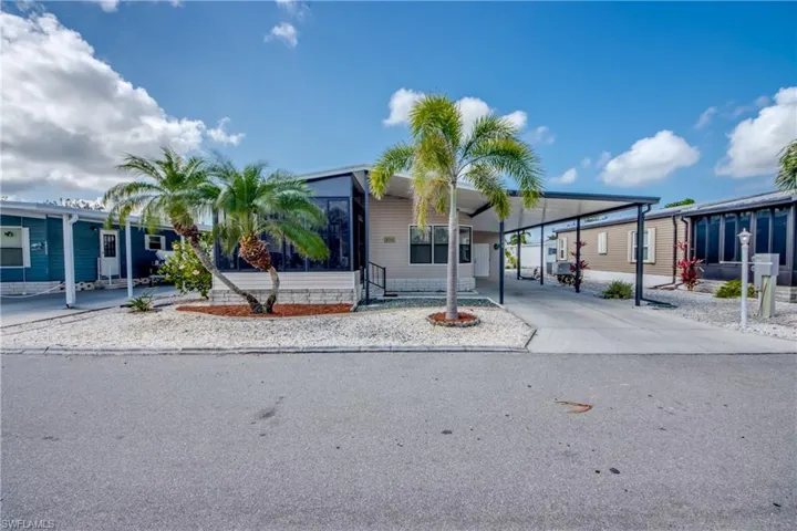 Manufactured / mobile home with concrete driveway and a carport