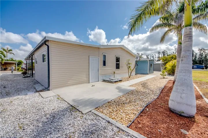 Back of house with a patio area and an outbuilding
