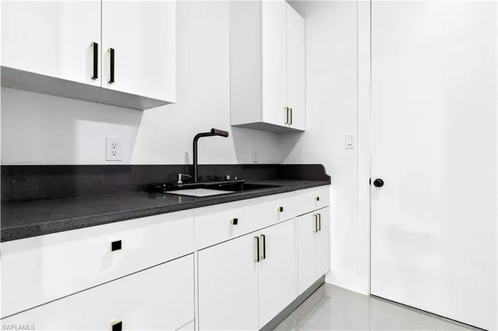 Kitchen with white cabinetry and a sink