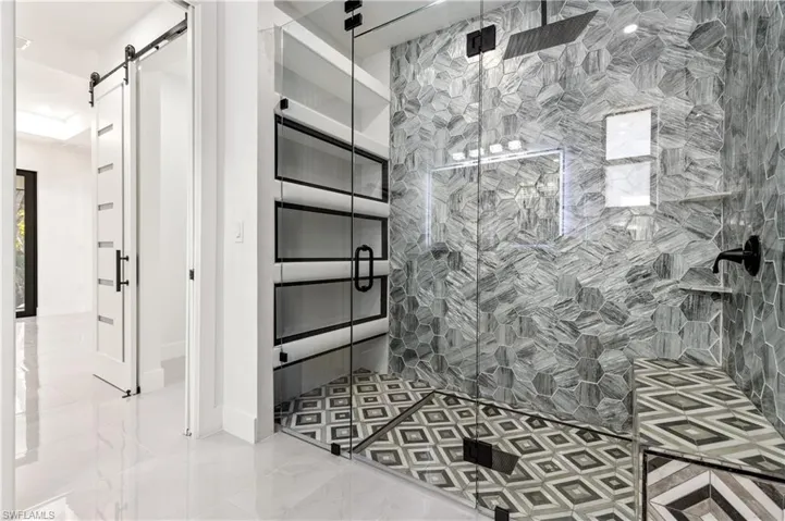 Bathroom with a shower stall and baseboards