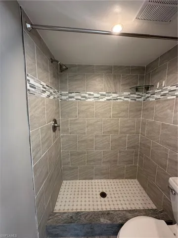 Full bathroom featuring a shower stall and toilet