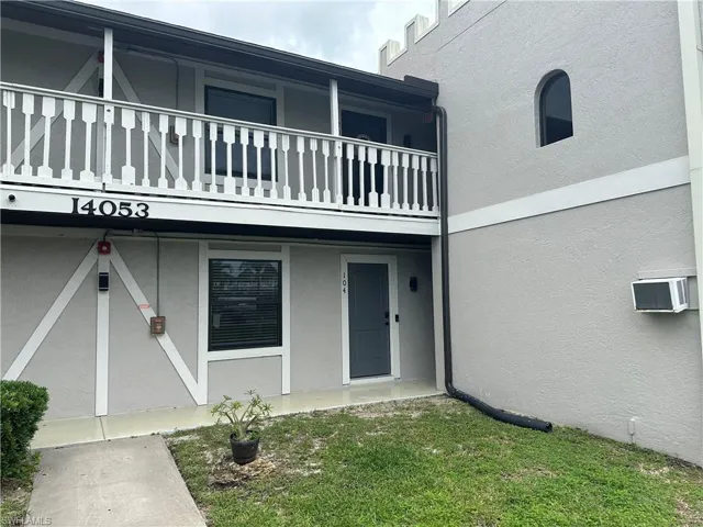 Entrance to property featuring stucco siding and a lawn