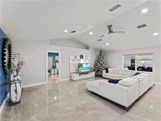 Living area featuring vaulted ceiling, a ceiling fan, and recessed lighting