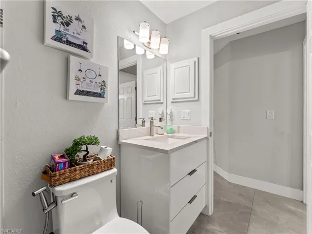 Bathroom with vanity and a textured wall