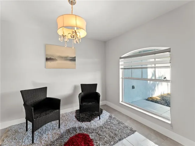 Living area with a chandelier and light tile patterned flooring