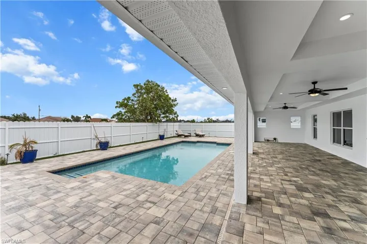 View of swimming pool with a patio area, a fenced backyard, and ceiling fan