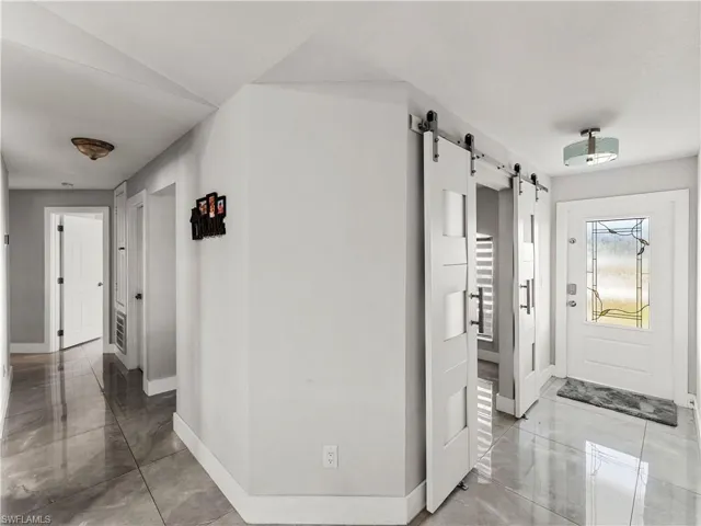 Hallway with baseboards and a barn door