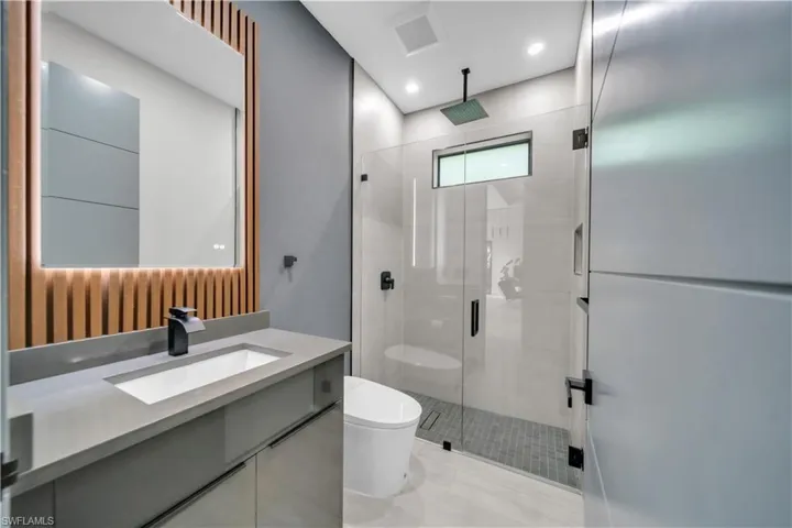 Contemporary bathroom featuring a floating vanity with integrated sink, matte black faucet, and concrete-finish countertop
