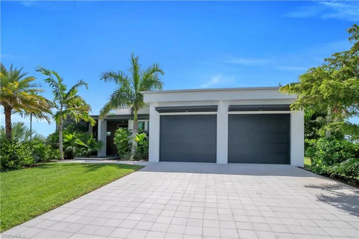 Modern single-story residence with a smooth stucco exterior and a flat roofline