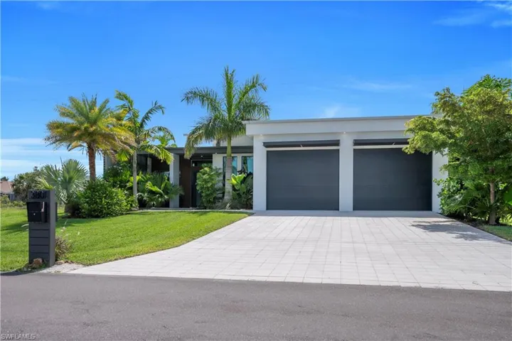 Modern single-story residence featuring a flat roofline and a two-car garage with dark gray doors
