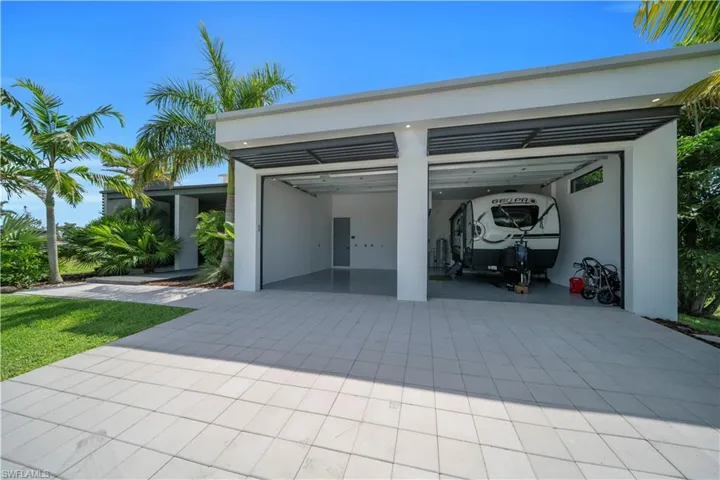 Modern two-bay garage with expansive paved driveway