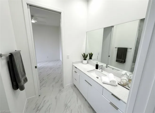 Bathroom with vanity and light marble finish floors