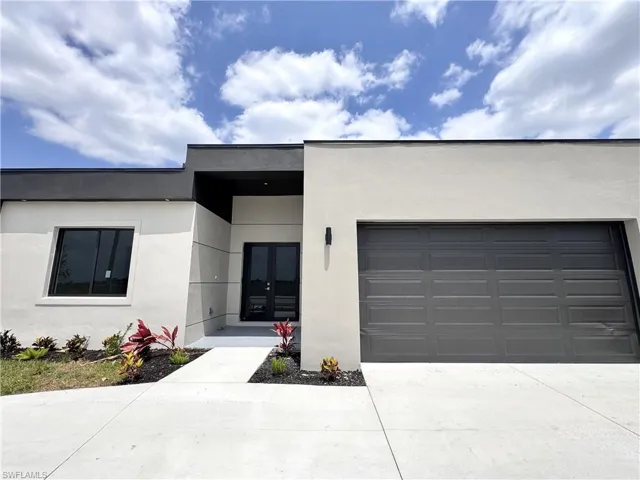 View of front of home featuring stucco siding, concrete driveway, and an attached garage