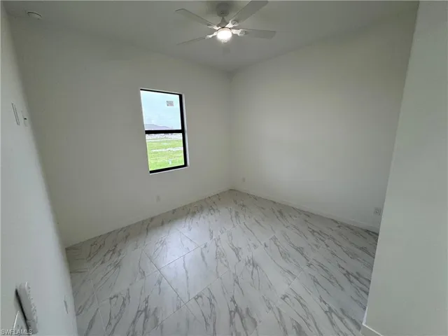 Empty room with light marble finish flooring and ceiling fan