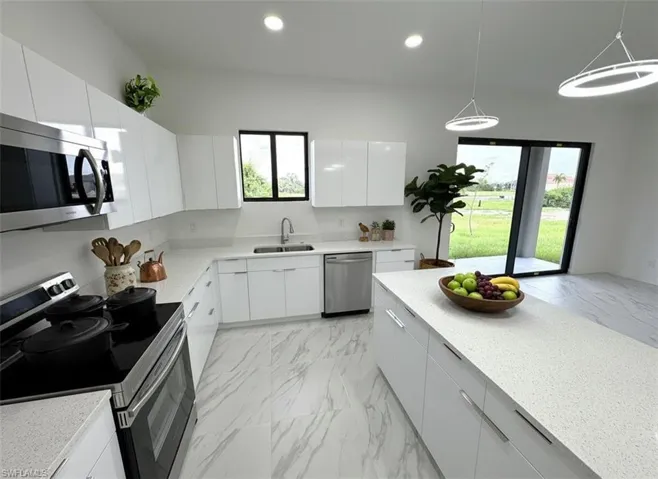 Kitchen featuring stainless steel appliances, modern cabinets, pendant lighting, white cabinets, and recessed lighting