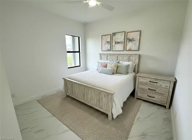 Bedroom featuring light marble finish flooring and a ceiling fan