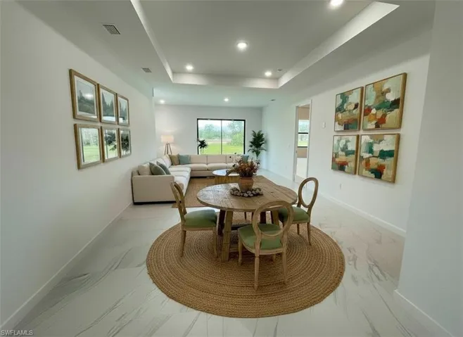 Dining room with a tray ceiling and recessed lighting
