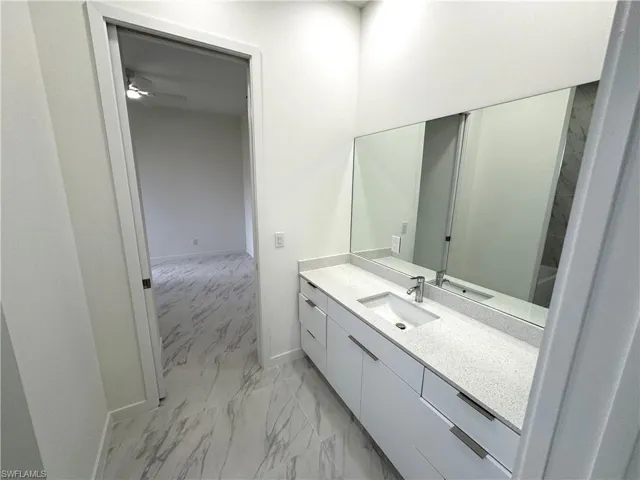 Bathroom with vanity and light marble finish flooring